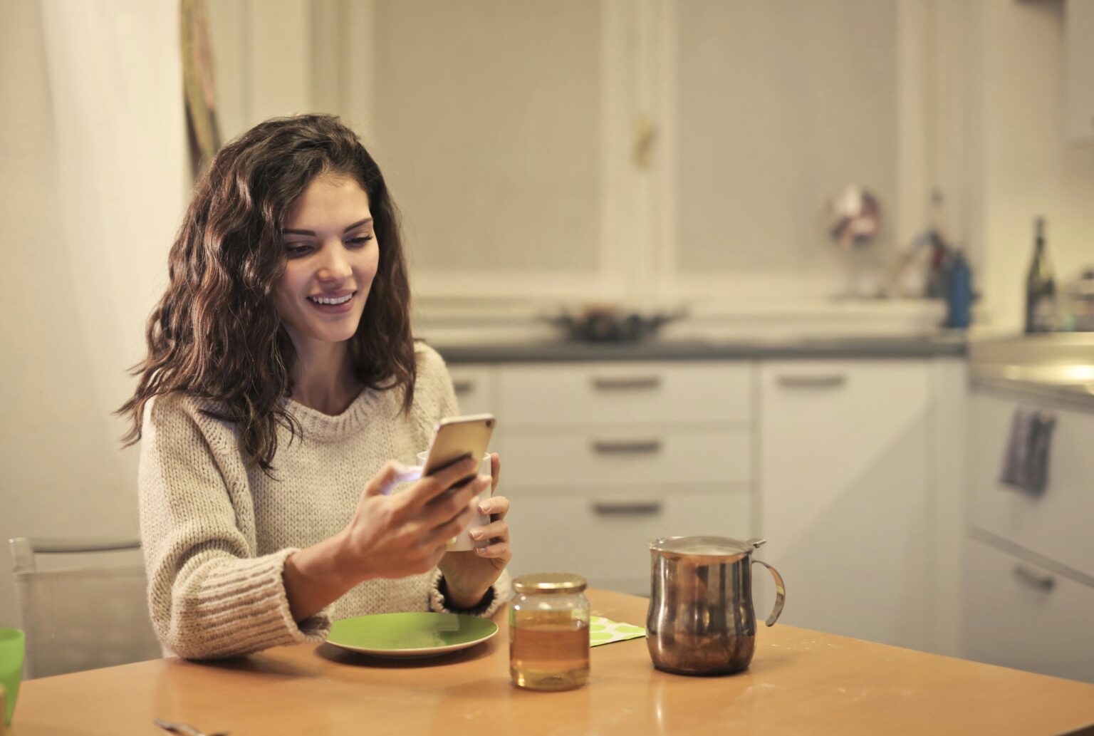 woman at a table looking at a mobile phone
